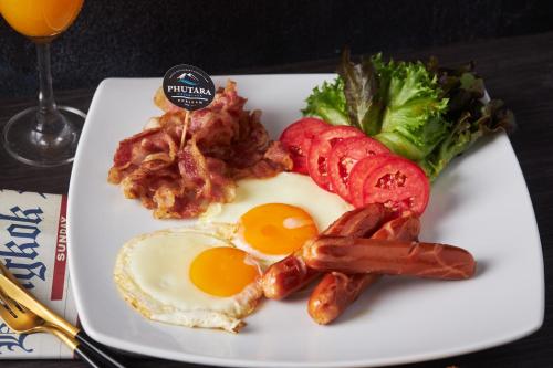 ein Frühstücksteller mit Eiern, Speck und Brokkoli in der Unterkunft Phutara Resort and Spa in Buriram