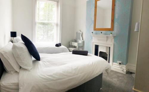 a bedroom with a bed with a mirror and a fireplace at April Lodge -3Bed-Sleeps 6-Parking-Spacious-Long Stays-Groups-Professionals-Contractors Welcome in Bournemouth