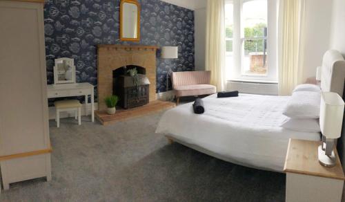 a bedroom with a large bed and a fireplace at April Lodge -3Bed-Sleeps 6-Parking-Spacious-Long Stays-Groups-Professionals-Contractors Welcome in Bournemouth