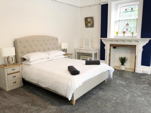a bedroom with a large white bed with a fireplace at April Lodge -3Bed-Sleeps 6-Parking-Spacious-Long Stays-Groups-Professionals-Contractors Welcome in Bournemouth