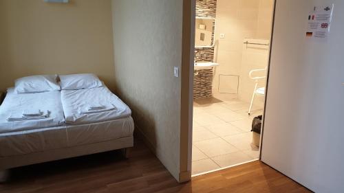 a small bedroom with a bed and a bathroom at Hôtellerie Saint Yves in Chartres