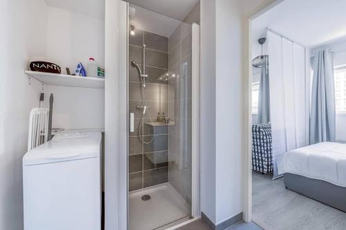 La salle de bains est pourvue d'une douche à l'italienne à côté d'un lit. dans l'établissement Studio Vatel Nantes, à Nantes