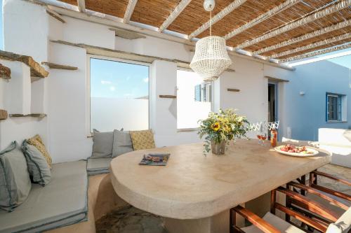 a kitchen and living room with a large wooden table at Golden Beach Studios & Suites in Tinos