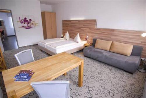 a living room with a couch and a table at Petul Apart Hotel Am Ruhrbogen in Bochum