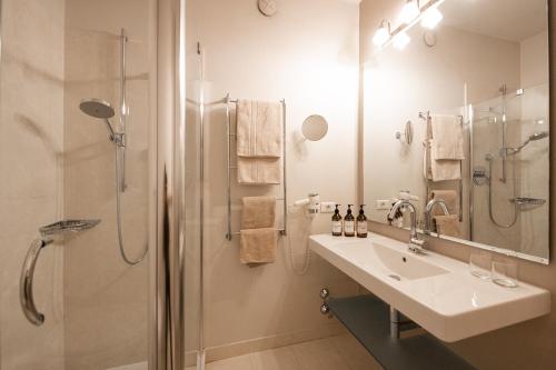 a bathroom with a sink and a shower at Hotel Pollinger in Merano