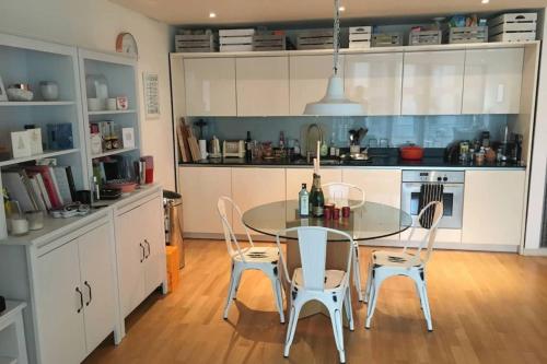 a kitchen with a table and chairs in a kitchen at Modern 3 Bedroom Apartment in Paddington in London