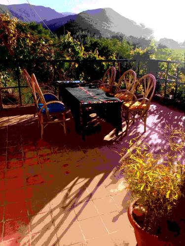 a table and chairs on a patio with a view at Gte Tawada - Haut-atlas - Room for 3 people in Agouti