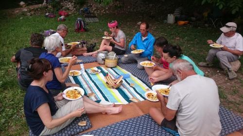 um grupo de pessoas sentadas à volta de uma mesa de piquenique a comer comida em Room in Guest room - Gite Tawada - Haut-atlas - Room for 3 people em Agouti
