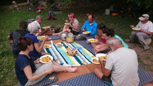 a group of people sitting around a picnic table eating food at Gte Tawada - Happy Valley - Room for 3 People in Agouti