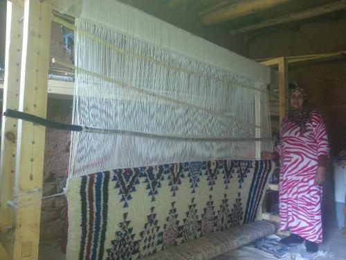 a woman standing next to a wall with a curtain at Gte Tawada - Happy Valley - Room for 3 People in Agouti