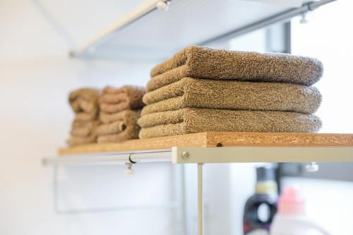 a pile of towels on a shelf in a bathroom at HAT Huruichi, near from Nara park, more than 5 parking space, 築3年の一軒家,駐車場5台以上可,グループでの宿泊に in Nara