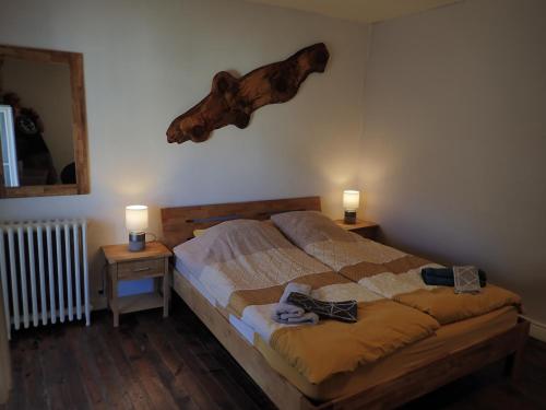 La Miramboise, chambres et table d hôtes في ميرامبو: غرفة نوم مع سرير وطاولتين مع مصابيح
