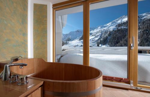 a bathroom with a tub with a view of a mountain at Chalet & Apart Hochfügen in Hochfugen