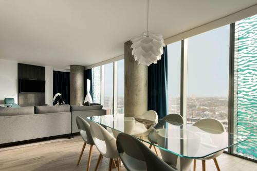 a dining room with a glass table and chairs at Radisson Blu Hotel, Birmingham in Birmingham