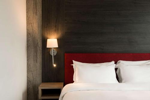 a bedroom with a bed with a red headboard at Radisson Blu Hotel, Birmingham in Birmingham