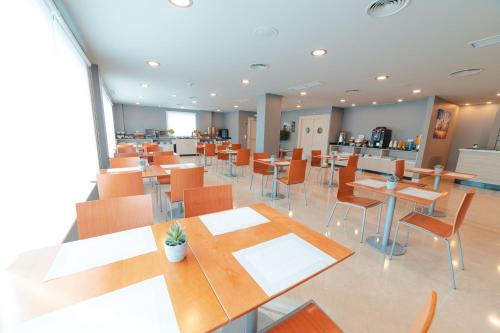 a dining room with tables and chairs in a cafeteria at Hotel Monte Rozas in Las Rozas de Madrid