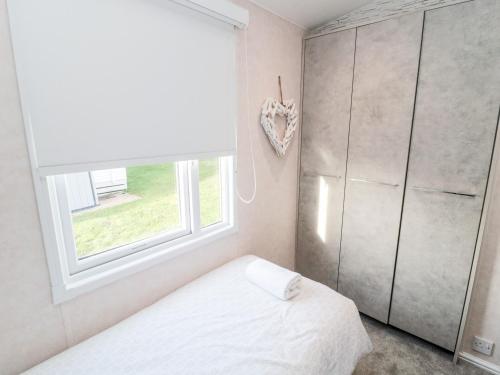 a bedroom with a bed and a window at 23 Valley View in Morpeth