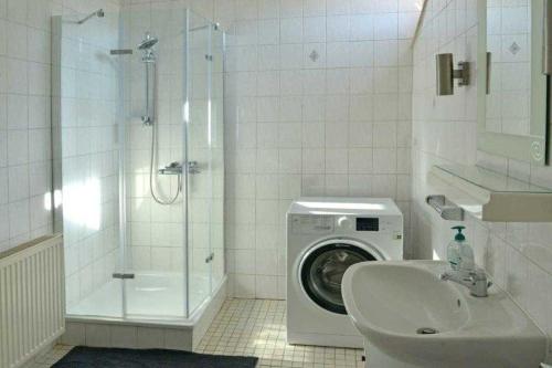 een badkamer met een wasmachine en een wasmachine bij Ferienwohnung Roessing 25194 in Bunde