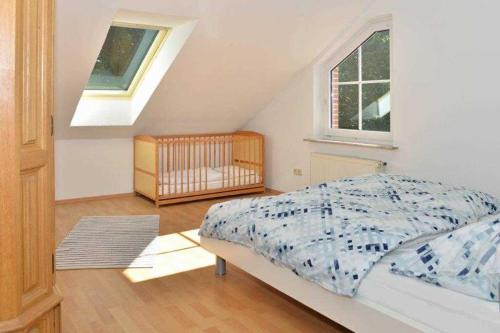 a bedroom with a bed and a window and a crib at Ferienwohnung Roessing 25194 in Bunde