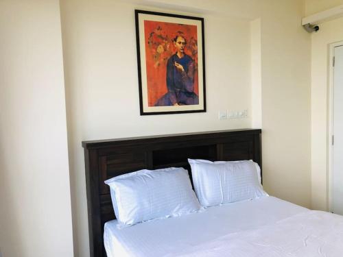 a bedroom with a bed with a picture on the wall at lovely 2-bedroom sea view serviced apartment dabolim goa in Dabolim