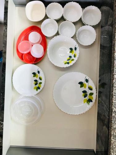a box filled with white plates and red bowls at lovely 2-bedroom sea view serviced apartment dabolim goa in Dabolim