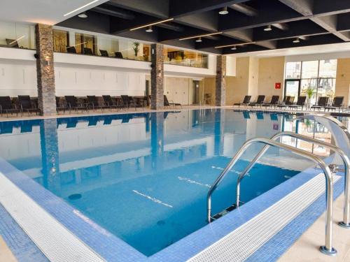 a large indoor swimming pool with blue water at Apartman Grk 5 in Zlatibor