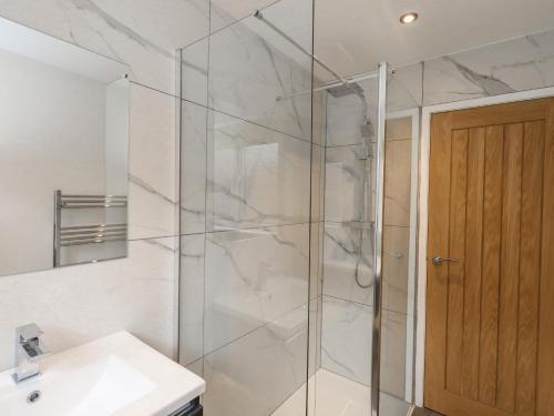 a bathroom with a shower and a sink at Woodview in Pooley Bridge
