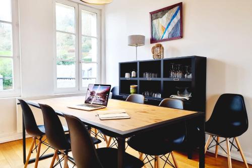 - une salle à manger avec une table et un ordinateur portable dans l'établissement Vue Panoramique sur la Baie de Seine Parking, à Honfleur