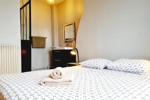 une chambre avec un lit avec des serviettes dessus dans l'établissement Vue Baie de Seine - Parking - Pont de Normandie, à Honfleur