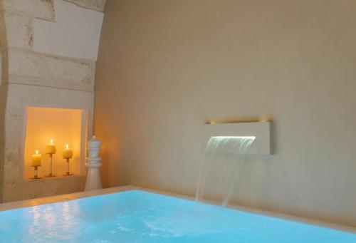 a swimming pool with a water fountain in a room at Eurydice Suite with Infinity Jacuzzi in Ostuni