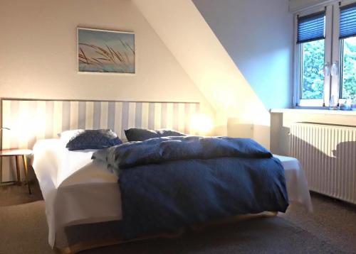 グドイェムにあるGudhjem unsere Ferienwohnung mit tollem Meerblickのベッドルーム1室(青い枕のベッド1台付)