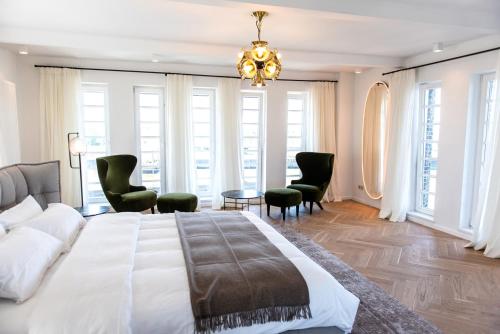 a bedroom with a large bed and chairs and a chandelier at Brands Loft in Hamburg