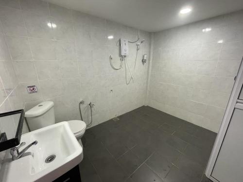 a bathroom with a shower and a toilet and a sink at The Sky Inn in Kuantan