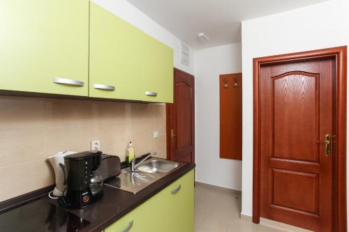 a kitchen with green cabinets and a sink at Apartments Ana Lopud in Lopud Island