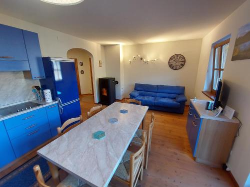 a kitchen and living room with a table and blue cabinets at Top location ski-to-door two-bedroom apartment in Bach