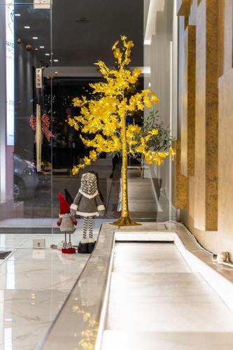 a tree with yellow leaves in a store window at Athens Panorama Project in Athens