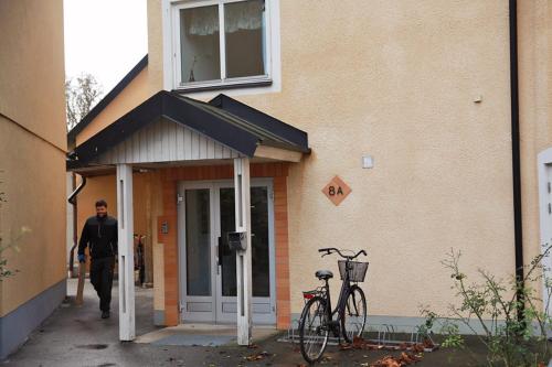 Ein Mann geht in ein Gebäude mit einem Fahrrad, das draußen geparkt ist. in der Unterkunft Birkagatan - Visby Lägenhetshotell in Visby