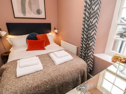 a bedroom with a bed with two pillows on it at Jaipur House in Richmond