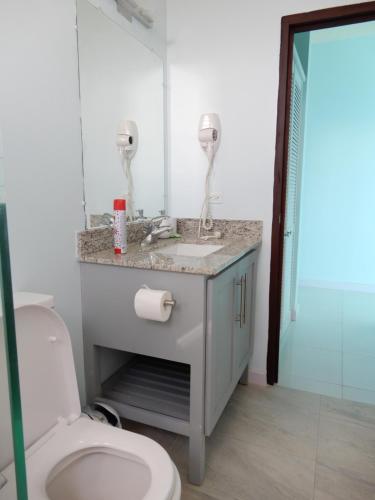 a bathroom with a sink and a toilet at Oistins Bayview Apartments in Christ Church