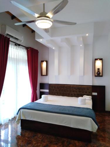 a bedroom with a large bed with a ceiling fan at Y&Y Residence in Kandy