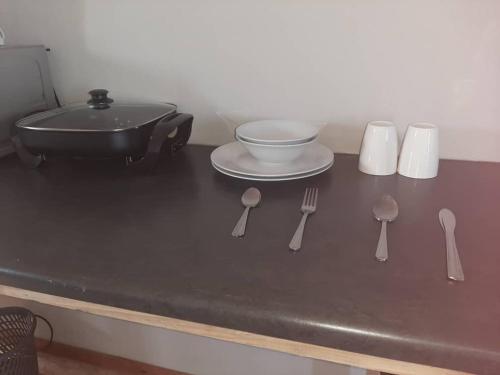 einen Tisch mit Küchenutensilien, einem Teller und einer Schüssel in der Unterkunft OrbanLife Lite Keetmanshoop in Keetmanshoop
