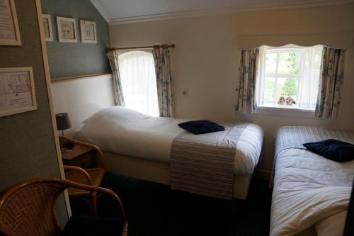 a hotel room with two beds and a window at Pension De Hoestinkhof in Markelo