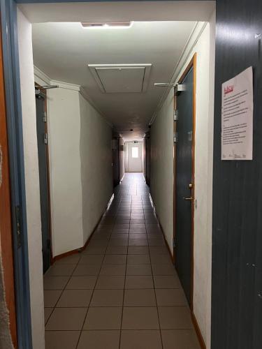 einen Flur mit einem langen Flur mit Türen und Fliesenböden in der Unterkunft Birkagatan - Visby Lägenhetshotell in Visby
