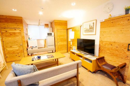 a living room with a couch and a television at kODATEL コダテル 札幌大通公園 101 in Sapporo
