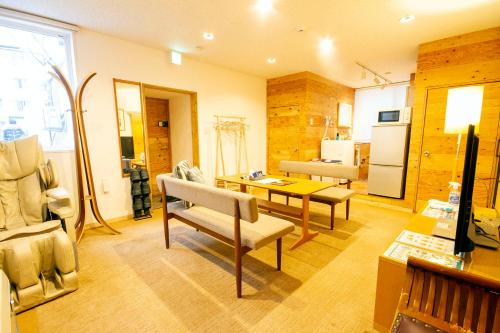 a living room with a table and chairs and a refrigerator at kODATEL コダテル 札幌大通公園 101 in Sapporo