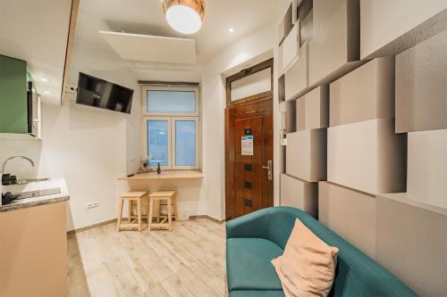 sala de estar con sofá azul y cocina en ZEUS Design Mini Apartment Erlach #10, en Viena