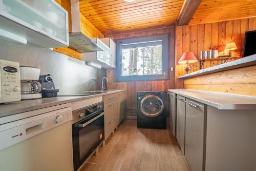 une cuisine avec lave-linge et sèche-linge dans une maison dans l'établissement Chalet des Ecureuils - 3 étoiles au pied des pistes, aux Angles
