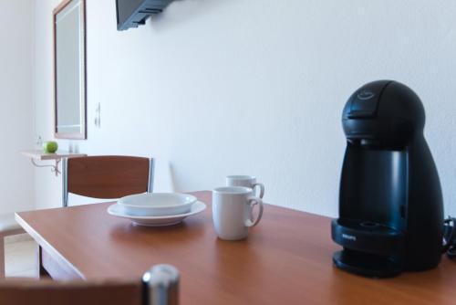 a coffee maker and a cup on a wooden table at Ilios 1 Central in Malia