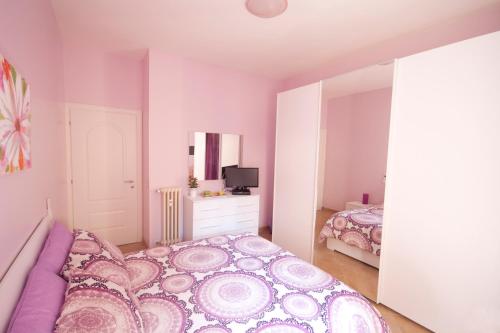 a pink bedroom with a bed and a tv at Sophie's Choice in Rome