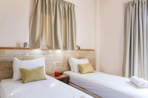 two beds sitting next to each other in a room at Ilios 1 Central in Malia